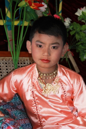 Young boy dressed up and made up for the ceremony before he goes off to become a monk.